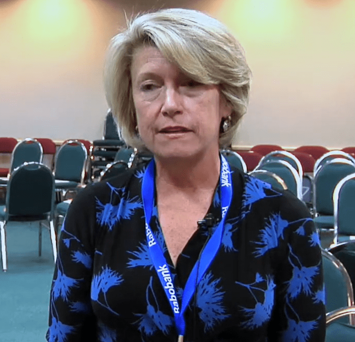 Judy McCarthy and Kevin McCarthy smiling together outdoors, surrounded by greenery, showcasing their close bond as a political couple